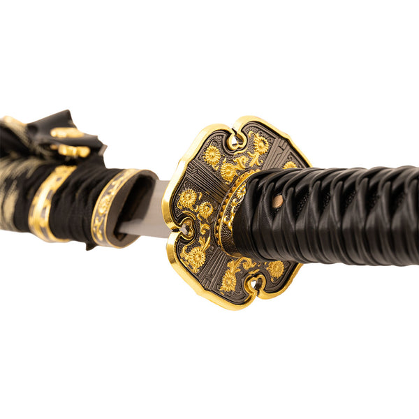 Close-up of the SMAI Forged Carbon Steel Katana - Dark Emperor, highlighting its gold and black hand guard, black wrapped full tang handle, and partially unsheathed striking blade.