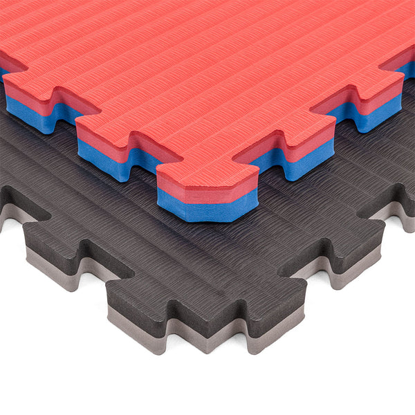 Two SMAI Jigsaw Mat - 3cm - Factory Seconds with cosmetic imperfections are stacked diagonally: the top shows red with a blue and white core, the bottom is black with a gray layer. Both mats feature textured surfaces.