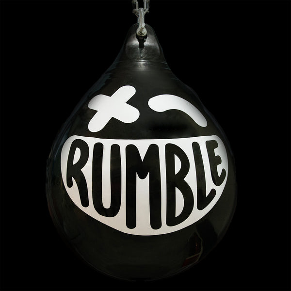 A black, teardrop-shaped balloon with a white, stylized smiling face and the word "RUMBLE" written across it. The face includes a "X" eye and an arched eyebrow, set against a plain black background.