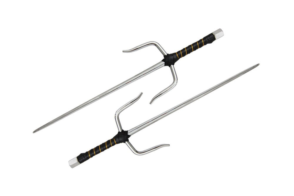 Two traditional metal sai weapons with black and gold-wrapped handles, each featuring a central pointed blade and two curved side prongs, displayed on a white background.