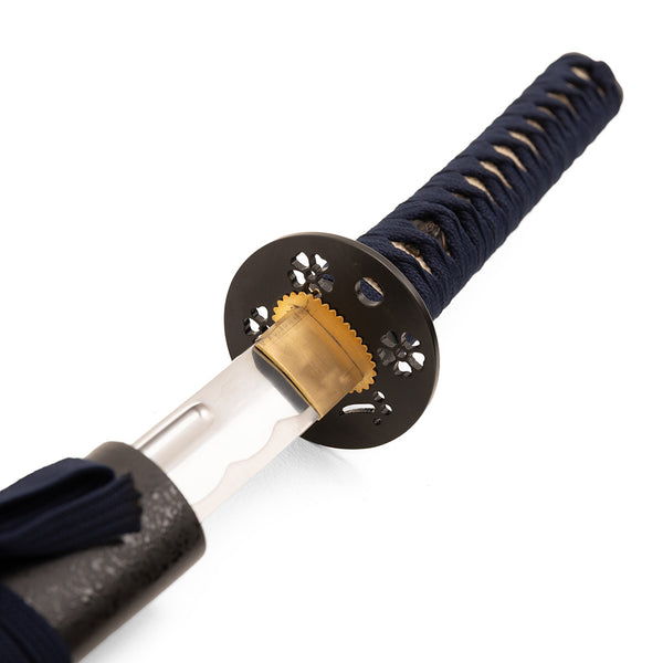A close-up view of the SMAI Aluminium Blue Display Katana - Virelais, highlighting its ornate tsuba (handguard), wrapped handle, and part of the blade with a wavy hamon pattern.