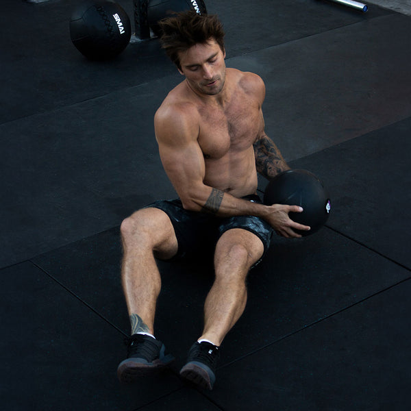 Man using 20kg Slam Ball for an ab exercise