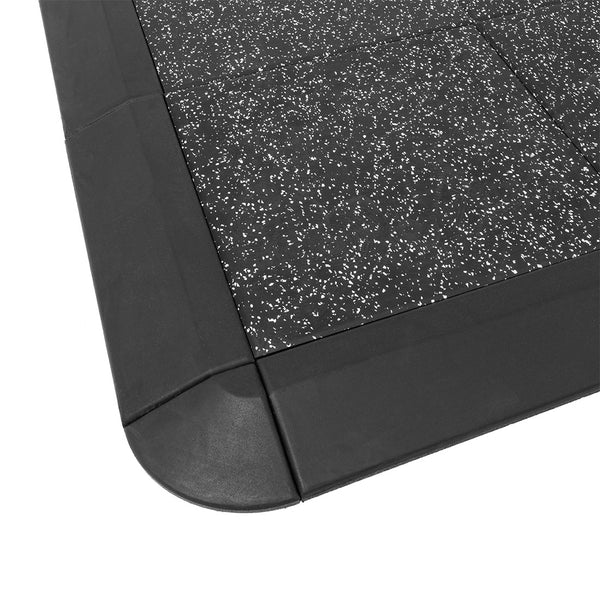 Close-up of the Weight Lifting Platform by No Sync To Channel Engine, featuring a black acoustic rubber mat with a white fleck pattern and rounded corners for impact protection, complemented by smooth edges enhancing the contrast.