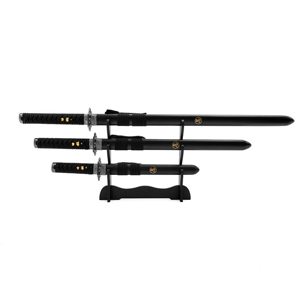 The SMAI Ninja 3pc Sword & Stand features three collectible black swords with decorative hilts and gold emblems, elegantly arranged on a black stand against a white background.