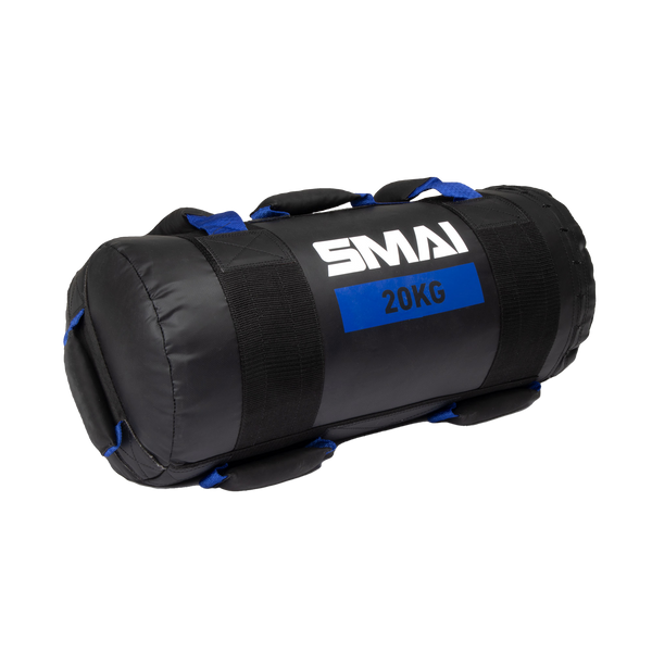 A black cylindrical fitness sandbag with blue handles and a label reading "SMAI 20KG" on the side, designed for weight training and strength exercises.