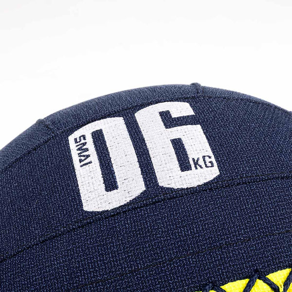 Close-up of an SMAI Wall Balls - Hybrid Range in dark blue with white "SMAI 06 KG" text. Features visible stitched seams, durable aramid fibre construction, and a small yellow detail at the base.