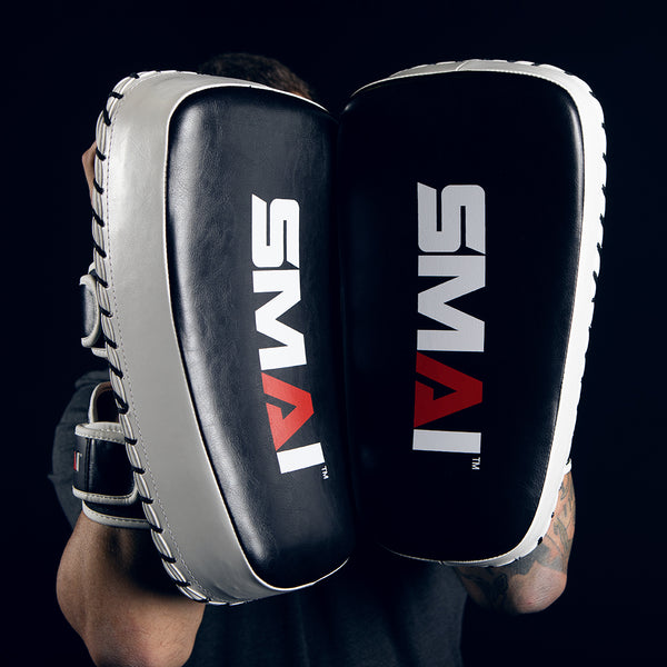 Man Holding Essentials Muay Thai Pads at Camera