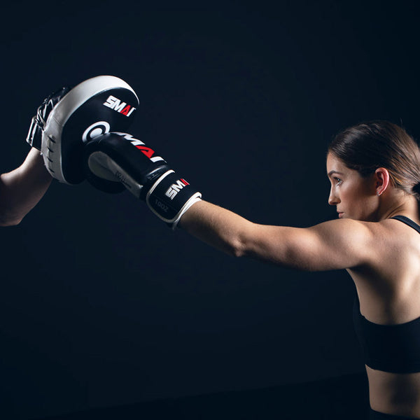 Woman punching the SMAI Essentials Boxing Mitts