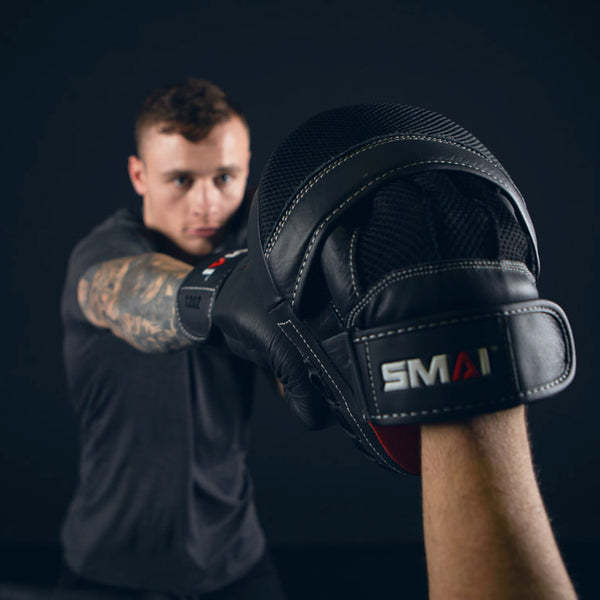 Man punching the Elite85 Boxing Mitts