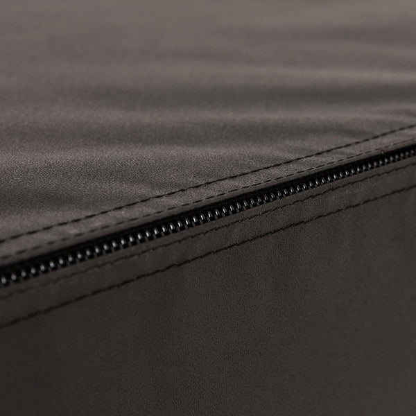 Close-up of a black zipper running along the edge of a dark fabric surface with visible stitching, as seen on the SMAI Plyometric Box - Foam Covered - Black Series, designed for safe and durable box jumps.