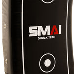 A close-up of the SMAI Kick Shield - Shoc Tec Curved, a black lightweight pad with white and red text, side stitching, and white target circles, designed for absorbing impact during kicks and hits.