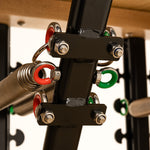 Close-up of metal springs with red and green rings attached to a black frame on the SMAI Pilates Chair, designed for strength training and core conditioning.