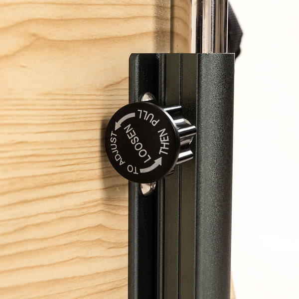 Close-up of SMAI Pilates Chair’s black adjustment knob on a light wood surface, labeled "PULL THEN LOOSEN TO ADJUST," with metal rail and handle visible for core conditioning and strength training.