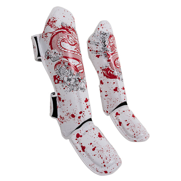 The SMAI Muay Thai Shin Instep Guard - White Dragon features white shin guards with red splatter, dragon and flower designs, black edging, adjustable straps, and EVA foam for comfort and durability.