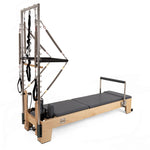 The SMAI Pilates - Classical Maple Reformer with Tower features a sturdy wooden frame, padded platform, and metal tower equipped with straps, springs, and resistance bands for versatile workouts.