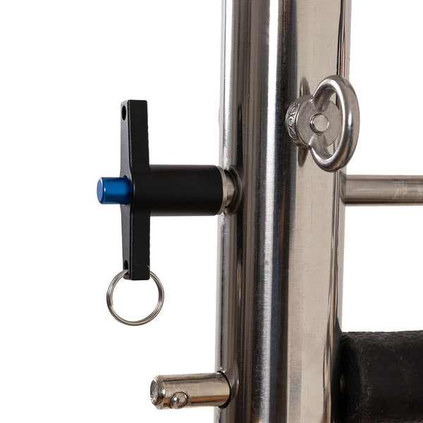 Close-up of a metal adjustment pin with black handle, blue tip, and silver keyring in a shiny vertical pole on the SMAI Pilates - Classical Maple Reformer with Tower.