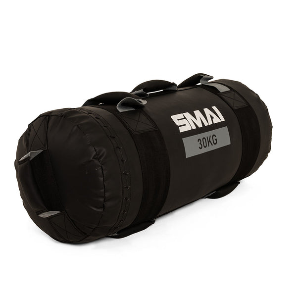 The SMAI Core Bags, made from rip-proof vinyl, are black cylindrical bags with handles and "SMAI 30KG" on the side—ideal for dynamic strength training and intense workouts.