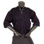 A black mannequin poses with hands on hips, dressed in the SMAI Deluxe Kendo Jacket—an indigo, double-layer keikogi made from 100% cotton—and pleated pants, set against a plain white background.