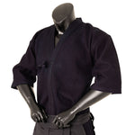 A black mannequin displays the SMAI Deluxe Kendo Jacket—an indigo double layer keikogi crafted from 100% cotton—featuring wide sleeves and a waist tie, with its arms bent and hands resting at the lower front.