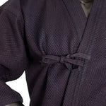Close-up of the SMAI Deluxe Kendo Jacket - Indigo Double Layer Keikogi, expertly crafted from 100% cotton and fastened at the waist with a fabric bow. The detailed sleeve and collar features of this indigo keikogi jacket are clearly visible.