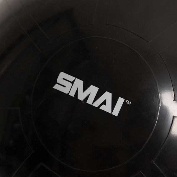 Close-up of the Commercial 65cm Gym Ball in black, featuring the "SMAI" brand name in white letters at the center. Subtle reflections and embossed lines can be seen on the surface of this commercial-grade gym ball.
