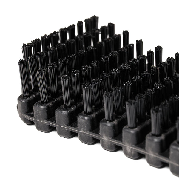 Close-up of the SMAI Barbell Cleaning Brush - Nylon, featuring stiff black nylon bristles arranged in rows on a rectangular base. The image highlights the detailed texture of both the bristles and base, emphasizing its effectiveness for barbell maintenance and cleaning tasks.