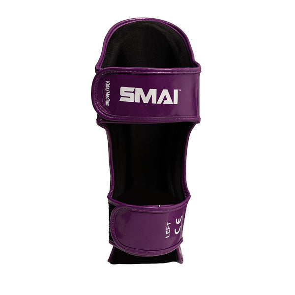 The Essentials Muay Thai Shin Instep Guard Kids - Purple by SMAI is a kids martial arts shin guard featuring white “SMAI” and “LEFT” text. It includes two adjustable straps for secure leg fit, making it an ideal choice for young athletes.