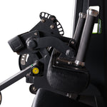 Close-up of the arm and handle components of the SMAI Leg Extension / Leg Curl Machine – 2 in 1, highlighting black padded grips, adjustment knobs, metallic levers, and bolts against a black background.