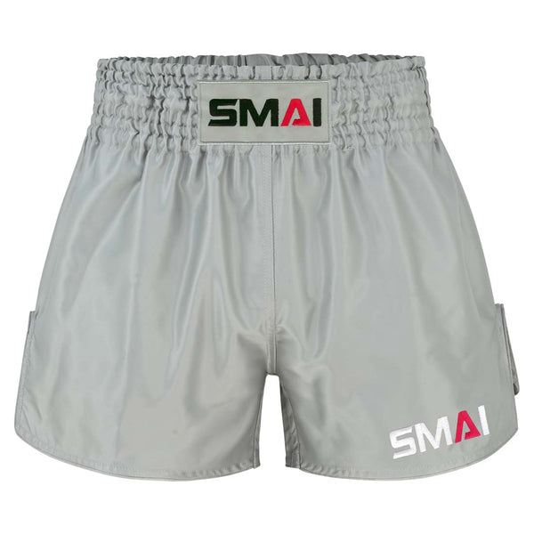 Grey SMAI Muay Thai Shorts - Grey satin polyester with an elastic waistband and brand logos on the front center and lower leg.