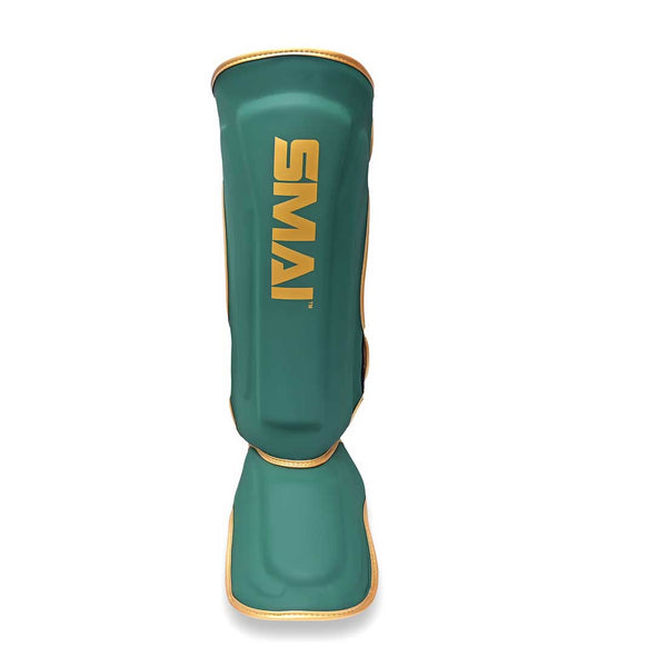 Introducing the Gold Series Muay Thai Shin Guards by SMAI in green and gold, featuring bold yellow "SMAI" branding on the front. Specially designed for leg protection in sports and martial arts, these shin guards offer superior impact absorption with high-density foam shielding.