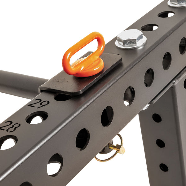 Close-up of a black metal frame with numbered holes, bolts, and an orange attachment ring secured to the frame—perfect for a garage gym and ideal as part of the SMAI Folding Wall Mounted Squat Rack.