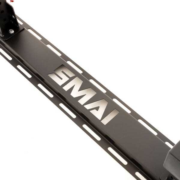 A close-up of a black metal component from the SMAI Folding Wall Mounted Squat Rack, featuring the "SMAI" brand name cut out in the center and elongated slots on either side—perfect for adding to your garage gym setup.
