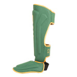 Introducing the SMAI Gold Series Muay Thai Shin Guards in Green/Gold, featuring durable EVA protection, integrated foot coverage, and a secure black strap—designed for martial arts or sports use and displayed against a white background.