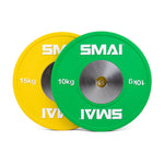 Two overlapping weight plates are displayed, ideal for Olympic weightlifting. The green plate is marked "10 kg" and the yellow one is "15 kg." Each has a metallic center with the SMAI logo in white, emphasizing their suitability as competition bumper plates from the Competition Bumper Plate Set with Barbell - 50kg by SMAI.