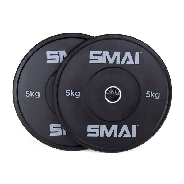 Two black 5 kg HD Bumper Plates from the "Sale Item" brand, featuring their weight prominently displayed, are stacked against each other. Made from high-quality rubber, these plates are ideal for Olympic lifting.