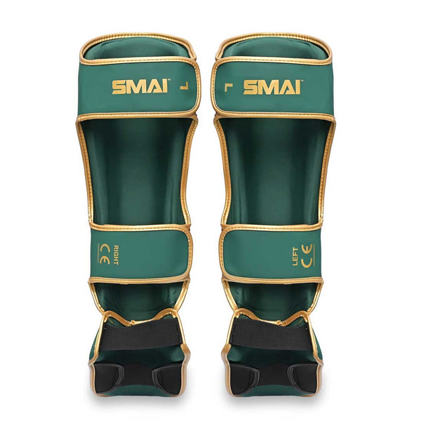 The SMAI Gold Series Muay Thai Shin Guards in Green/Gold are marked "LEFT" and "RIGHT" for easy identification. Designed with adjustable straps for a secure fit, these shin guards feature high-density foam padding and multi-layer EVA protection, delivering maximum safety and superior comfort during training or competition.