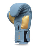 The SMAI Gold Series Boxing Glove - Light Blue/Gold is shown upright with the thumb tucked in, featuring a black Velcro strap at the wrist displaying "GOLD" and "12OZ" in gold text. Designed for superior wrist support, these gloves provide both comfort and security during intense training sessions.