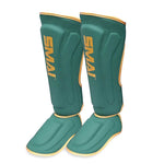 Introducing the Gold Series Muay Thai Shin Guards in Green/Gold by SMAI. These guards feature a striking green design with gold trim and "SMAI" boldly displayed in gold lettering on the front. Engineered for martial arts protection, they offer multi-layer EVA padding for superior durability and comfort.