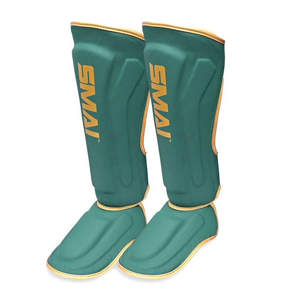 Introducing the Gold Series Muay Thai Shin Guards in Green/Gold by SMAI. These guards feature a striking green design with gold trim and "SMAI" boldly displayed in gold lettering on the front. Engineered for martial arts protection, they offer multi-layer EVA padding for superior durability and comfort.