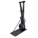 A stationary SMAI AirMag X Skier with a vertical frame, digital display, and a fan resistance flywheel mounted on a floor platform.
