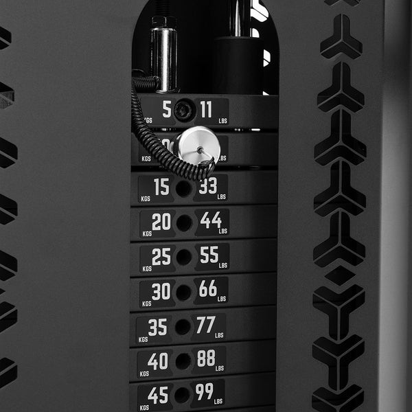 Close-up of the SMAI Functional Trainer’s dual weight stack, showing plates labeled in kg and lbs with the pin set at 11 kg (25 lbs). The black frame has geometric cutouts, making it a stylish choice for any home gym.