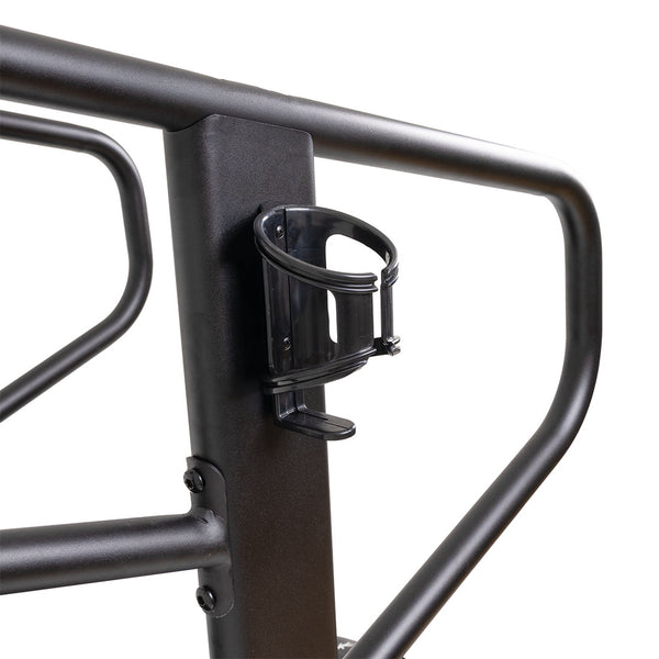 Close-up of a black metal bike rack with a black water bottle holder, both as durable as the SMAI Air Runner Curved Treadmill with Adjustable Resistance. The rack has sturdy tubular bars and a vertical support where the holder is attached.