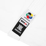Close-up of a white Kata Gi from SMAI, featuring a WKF-approved patch with a multi-colored circle and "SMAI," alongside a black patch with white Japanese characters and the word "Arashi," highlighting its approval by the Karate Federation.