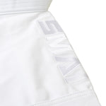 A close-up of SMAI's WKF Karate Uniform - Premium Kata Gi - Arashi features a white fabric with an embossed "SMK" logo. The smooth texture and precise stitching mirror its elite Karate Federation standards, with the folded fabric displaying a slightly angled logo.