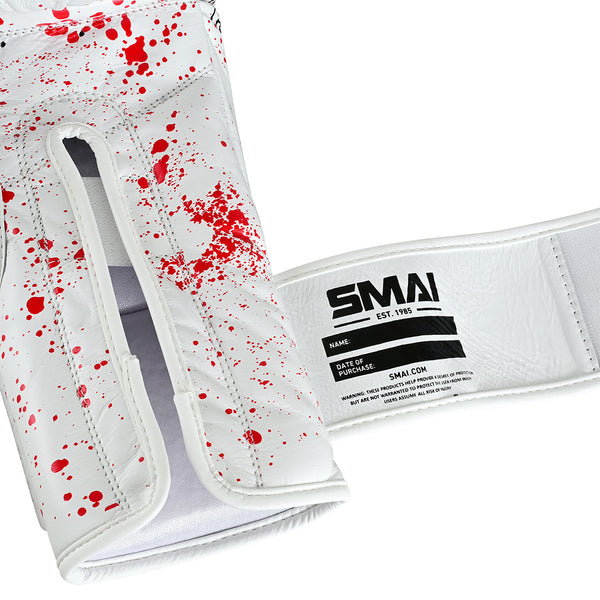 Close-up of the Boxing Glove - White Dragon Limited Edition by SMAI. Features durable white cowhide leather with red splatter, open palm, SMAI Velcro strap, and fields for name and date—crafted with the resilience of a boxing glove.