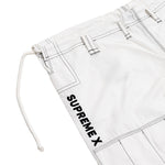 Close-up of the SMAI Supreme X Brazilian Jiu Jitsu Uniform in white, made from durable Rip Stop fabric with black stitching, belt loops, a drawstring, and "SUPREMEX" printed vertically in bold black letters on the side.