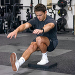 Man pistol squatting on a Black SMAI Balance pad block