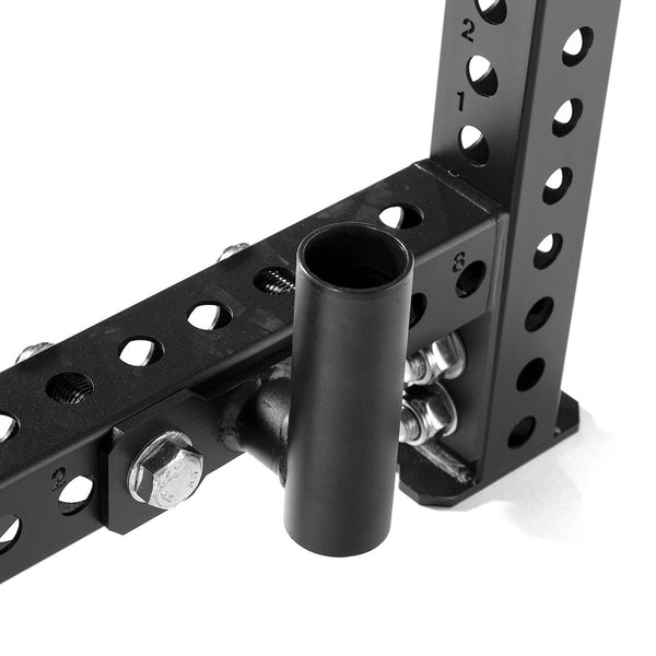 A close-up view of a black metal bracket featuring multiple holes and several bolts, part of the SMAI Vanta Series Half Power Rack Core Package. It includes a cylindrical attachment that connects to the structure, making it an ideal component for beginners in their fitness journey.