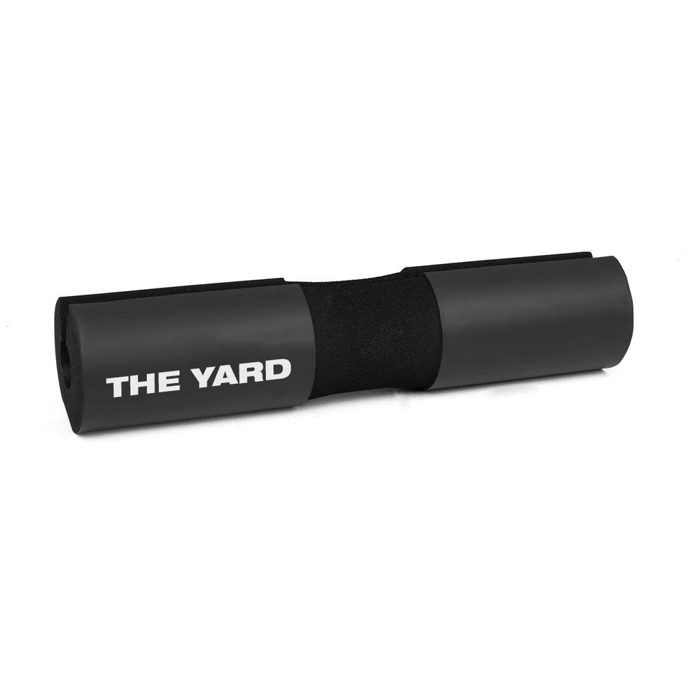 The SMAI The Yard - Barbell Pad / Hip Thruster Pad in black foam features "THE YARD" in white, ideal for weightlifting, squats, or hip thrusts to ensure comfort and security during gym workouts.