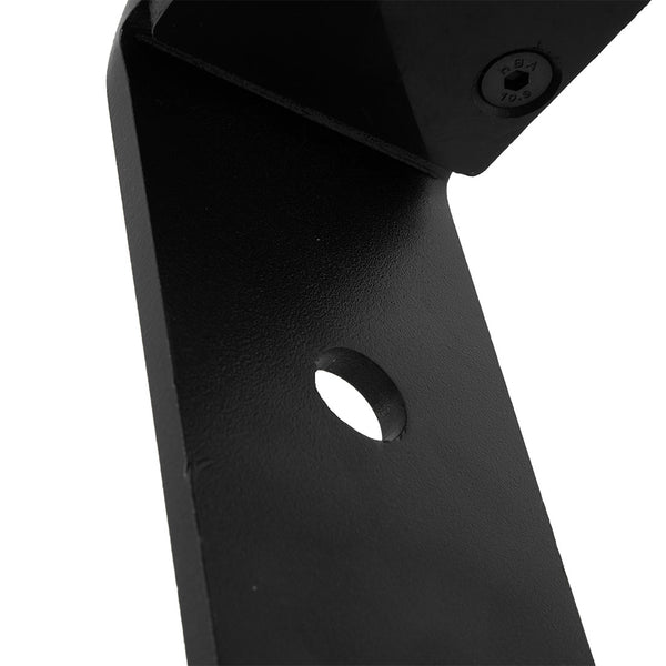 Close-up of the X-Frame / Wall Mount Barbell Hanger by SMAI, featuring a black metal design with a central circular hole. A screw is visible in the upper corner, and its textured metal surface details perfectly complement the functionality of Olympic barbells.